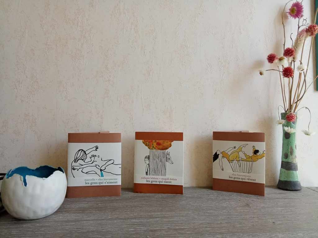 3 livres illustrés près d'un vase